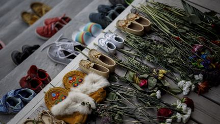 Des fleurs et chaussures, devant l'entrée du Mohawk Institute, une ancienne école réservée aux enfants autochtones à Toronto, Ontario (Canada) le 31 mai 2021. (COLE BURSTON / AFP)