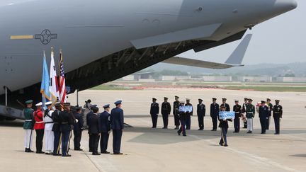 Des gardes d'honneur des Nations unies portent des boîtes contenant des restes présentés comme ceux de militaires américains tués pendant la guerre de Corée, restitués par la Corée du Nord et débarqués sur la base aérienne d'Osan (Corée du Sud), le 27 juillet 2018. (POOL NEW / REUTERS)