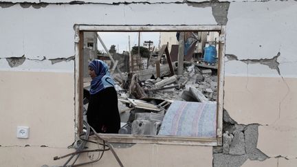 Une femme revient dans sa maison détruite de Beit Lahia, un quartier qui a subi de gros dommages.  