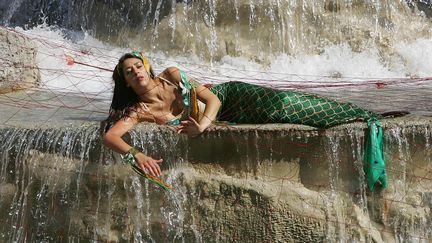 Une activiste de Greenpeace d&eacute;guis&eacute;e en sir&egrave;ne manifeste &agrave; Rome (Italie), le 13 juillet 2006. (MAX ROSSI / REUTERS)