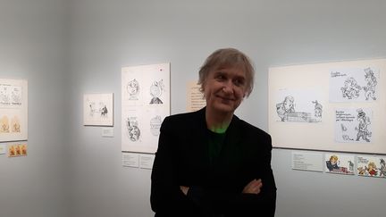 Plantu, dessinateur et caricaturiste, devant ses dessins exposés à la Bibliothèque nationale de France, à Paris en mars 2018. (ANNE CHÉPEAU / FRANCEINFO)