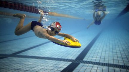 Des enfants s'entra&icirc;nent dans une piscine de Hangzhou (Chine) le 2 ao&ucirc;t 2012. (CARLOS BARRIA / REUTERS)