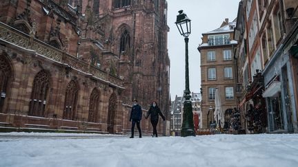 Des personnes marchent près de la cathédrale à Strasbourg (Bas-Rhin), en vigilance orange "grand froid", le 10 février 2021. (PATRICK HERTZOG / AFP)