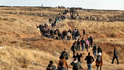 Des Syriens se dirigent vers la prison de Sednaya, le 9 décembre 2024, dans l'espoir de retrouver la trace de leurs proches disparus. (OMAR HAJ KADOUR / AFP)