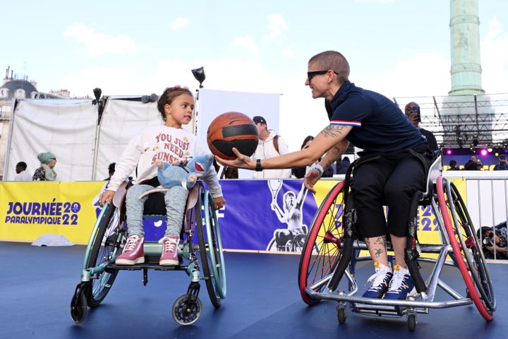 Marie Patouillet s'essaie au basket fauteuil avec une jeune fille lors de la journée paralympique à Paris, le 8 octobre 2022. (MILLEREAU PHILIPPE / KMSP / AFP)