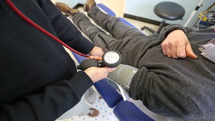 Un médecin de campagne prend la tension d'un patient. (MAXPPP)