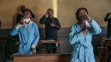 Des étudiants malgaches boivent du Covid-Organics, une tisane présentée par le président malgache Andry Rajoelina, comme un remède contre le coronavirus. Mais l’efficacité de cette boisson à base de plantes a été largement remise en question par la communauté scientifique. Très vite, l’affaire s’est politisée, précise franceinfo Afrique. Dans une interview accordée le 11 mai 2020 à RFI, Andry Rajoelina est revenu sur les nombreuses critiques et mises en garde contre ce remède-miracle, venues de l’Union africaine, de la Cédéao (Communauté économique des Etats d’Afrique de l’Ouest) et surtout de l’OMS, l’Organisation mondiale de la santé.&nbsp; &nbsp; &nbsp; &nbsp; (RIJASOLO / AFP)