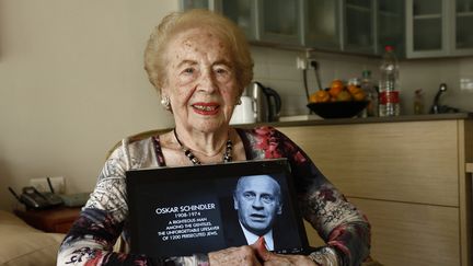 Mimi Reinhardt le 23 novembre 2019 en Israël, à&nbsp;Herzliya où elle s'était installée en 2007, tenant un portrait d'Oskar Schindler (GIDEON MARKOWICZ / AFP)