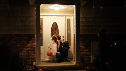 Des enfants sonnent &agrave; la porte d'une maison &agrave; Nyack, dans la banlieue de New York (Etats-Unis), pour r&eacute;clamer des bonbons, le 31 octobre 2008. (MIKE SEGAR / REUTERS)