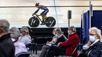 Un membre de l'équipe de France de cyclisme sur piste s'entraîne sous le regard des personnes qui viennent de se faire vacciner contre le Covid-19 dans le centre de vaccination du vélodrome de Saint-Quentin-en-Yvelines. (SADAK SOUICI / LE PICTORIUM / MAXPPP)