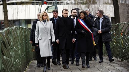 Emmanuel Macron entouré de son épouse Brigitte et de la maire de Paris Anne Hidalgo, sur les lieux de la mort du policier Ahmed Merabet, dimanche 7 janvier 2018. (CHRISTOPHE ENA / AFP)