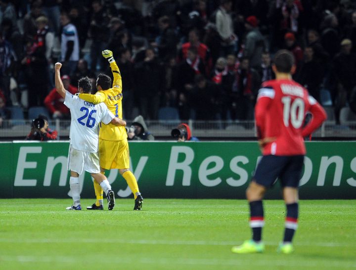 Le gardien de l'Inter Milan, Julio C&eacute;sar (en jaune), et le d&eacute;fenseur milanais Christian Chivu (en blanc) c&eacute;l&egrave;brent leur victoire face &agrave; Lille, le 18 octobre 2011, sous le regard du Lillois Hazard. (Philippe Huguen / AFP)