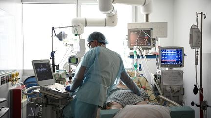 Un membre de l'unité de soins intensifs de l'hôpital Georges Pompidou à Paris au chevet d'un patient, le 6 avril 2021. (ANNE-CHRISTINE POUJOULAT / AFP)