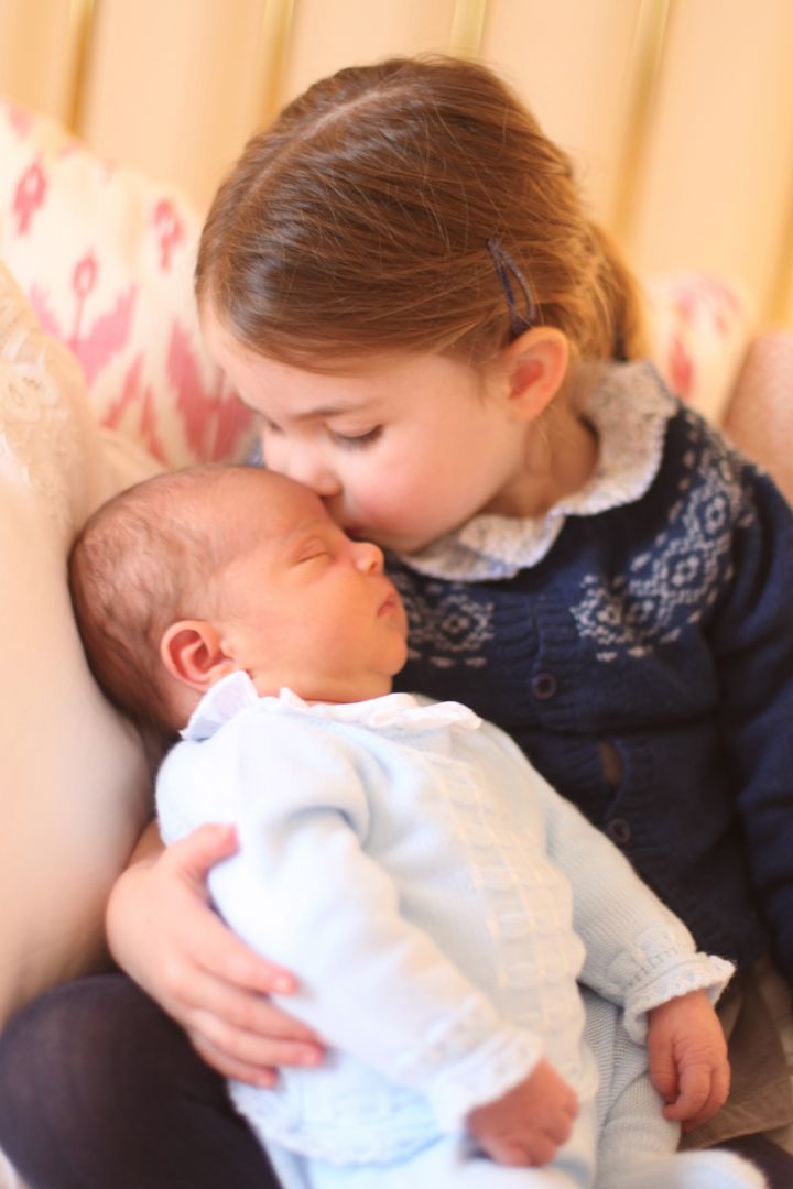 La princesse Charlotte embrasse son frère Louis sur le front, le 2 mai 2018 au palais de Kensington (Royaume-Uni). (DUCHESS OF CAMBRIDGE / KENSINGTON PALACE / AFP)