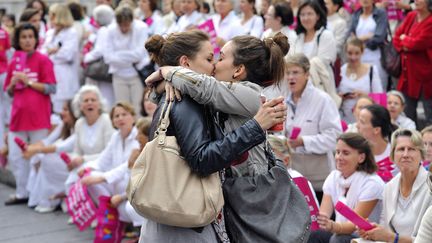 #LES SYMBOLES23 octobre 2012, Marseille (Bouches-du-Rh&ocirc;ne). Choqu&eacute;es par des propos entendus lors d'une manifestation d'Alliance VITA contre la proposition de loi pour le mariage pour tous, deux jeunes filles h&eacute;t&eacute;rosexuelles s'embrassent spontan&eacute;ment devant les manifestants m&eacute;dus&eacute;s. &laquo; Le baiser de Marseille &raquo; est n&eacute; et le d&eacute;bat est officiellement ouvert. (GERARD JULIEN / AFP)