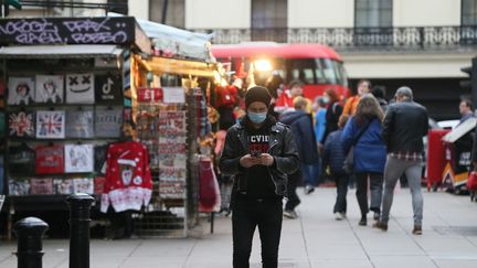 Un piéton à Londres (Royaume-Uni), le 15 décembre 2021. (HASAN ESEN / ANADOLU AGENCY / AFP)