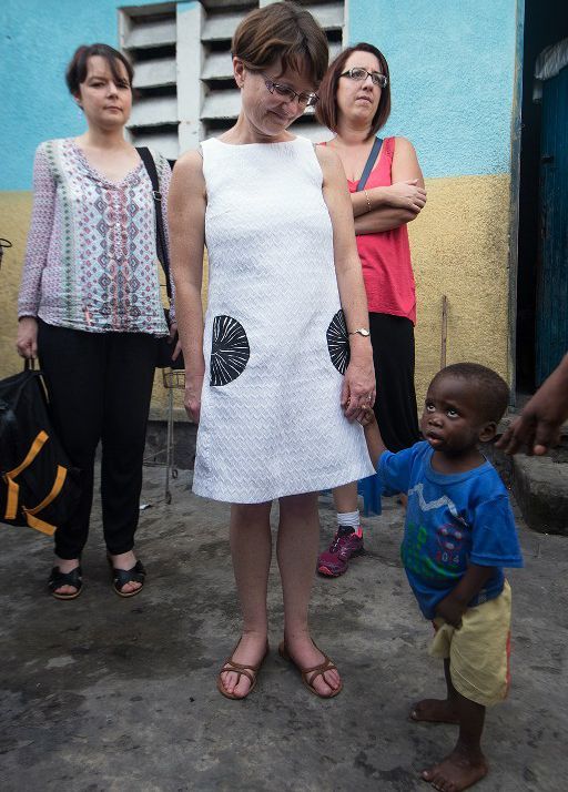 Une maman adoptive française tient par la main un petit garçon congolais à la maison de l'espoir à Kinshasa, le 26 novembre 2015. (PhotoAFP/Junior Kannah)