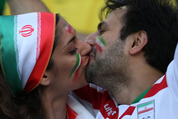 Des supporters iraniens s'embrassent pendant la rencontre Iran-Nigeria, le 16 juin 2014, &agrave; Curitiba, au Br&eacute;sil.&nbsp; (BEHROUZ MEHRI / AFP)