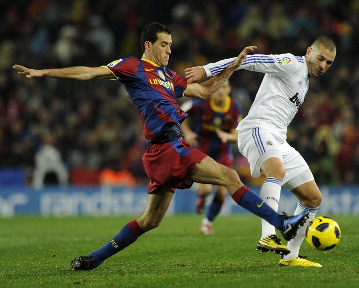 Karim Benzema en duel avec Sergio Busquets le 29 novembre 2010 au Camp Nou. (JAVIER SORIANO / AFP)