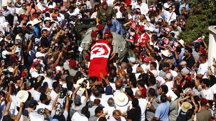 Une foule &eacute;mue assiste au d&eacute;part du cort&egrave;ge fun&egrave;bre du d&eacute;put&eacute; assassin&eacute; Mohamed Brahmi, le 27 juillet 2013 &agrave; Tunis (Tunisie).&nbsp; (ZOUBEIR SOUISSI / REUTERS)