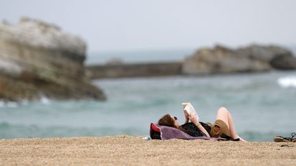 Une femme lit au bord de la plage à Biarritz, en avril 2015
 (IROZ GAIZKA / AFP)
