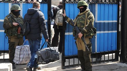 Des officiers ukrainiens quittent le&nbsp;quartier g&eacute;n&eacute;ral de la flotte ukrainienne &agrave; S&eacute;bastopol, en Crim&eacute;e&nbsp;(Ukraine), le 19 mars 2014, apr&egrave;s la prise de contr&ocirc;le de la base par les forces russes. (VIKTOR DRACHEV / AFP)