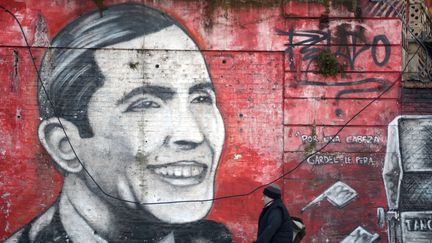 A Buenos Aires, un homme passe devant un graff représentant Carlos Gardel, en juin 2015
 (EITAN ABRAMOVICH / AFP)