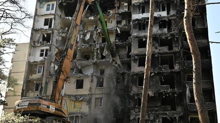 Des ouvriers démantèlent un immeuble lourdement endommagé dans la ville d'Irpin, le 21 avril 2023, au moment de l'invasion militaire de l'Ukraine par la Russie. (GENYA SAVILOV / AFP)