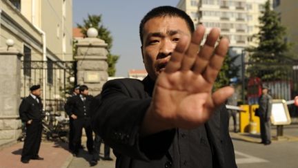 Un policier en civil chinois empêche un photographe de l'AFP de photographier la maison de l'épouse de Liu Xiaobo (AFP/PETER PARKS)