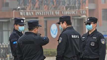 Des agents de sécurité devant l'insitut de virologie de Wuhan (Chine), mercredi 3 février 2021, lors d'une visite d'experts de l'OMS.&nbsp; (HECTOR RETAMAL / AFP)