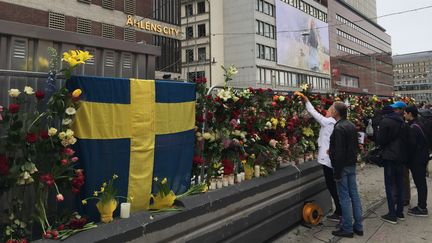 Des habitants se recueillent devant les lieux de l'attentat, à Stockholm (Suède), le 8 avril 2017. (FU YIMING / NURPHOTO / AFP)