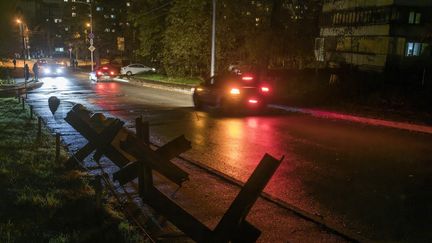 Des voitures longent une artère plongée dans le noir à Kiev (Ukraine), le 4 novmebre 2022. (MAXYM MARUSENKO / NURPHOTO)