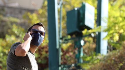 Un homme au téléphone à côté d'une antenne 5G. Photo d'illustration. (JEAN FRAN?OIS OTTONELLO / MAXPPP)