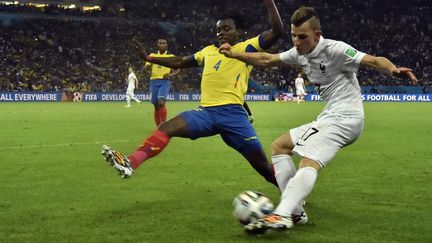 Le d&eacute;fenseur fran&ccedil;ais Lucas Digne centre sous la pression de l'Equatorien Juan Paredes, le 25 juin 2014, &agrave; Rio de Janeiro (Br&eacute;sil). (RODRIGO BUENDIA / AFP)