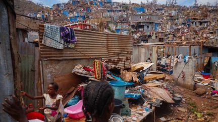 Une femme et un enfant dans le quartier de Kawani à Mamouzou, le 20 décembre 2024 après le passage du cyclone Chido. (DIMITAR DILKOFF / AFP)