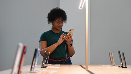 Une employée d'Apple utilise un iPhone lors de l'ouverture d'un magasin à Washington (Etats-Unis), le 9 mai 2019. (CLODAGH KILCOYNE / REUTERS)