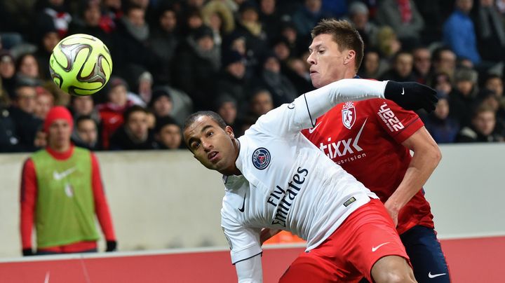 Le milieu de terrain parisien Lucas devant le Lillois Jonathan Delaplace, le 3 d&eacute;cembre 2014 au stade Pierre-Mauroy, &agrave; Villeneuve-d'Ascq (Nord). (PHILIPPE HUGUEN / AFP)