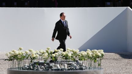 Devant le président, 86 roses blanches ont été déposées en souvenir des&nbsp;victimes de l'attentat. (ERIC GAILLARD / POOL)