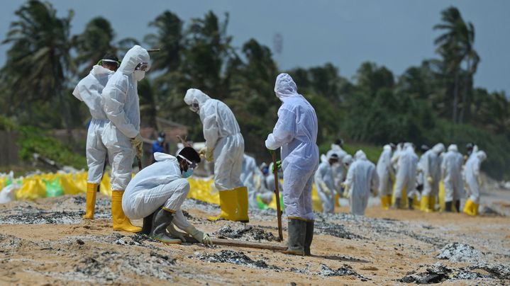 Des membres de la marine sri-lankaises nettoient la plage jonchée de microplastiques échappés du porte-conteneurs en perdition "MV X-Press Pearl", le 31 mai 2021. (LAKRUWAN WANNIARACHCHI / AFP)