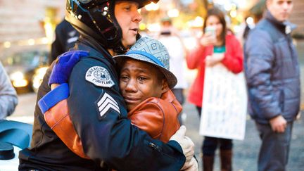 Un jeune gar&ccedil;on de 12 ans enlace un policier pendant une manifestation &agrave; Portland (Oregon, Etats-Unis), le 25 novembre 2014. (JOHNNY NGUYEN / AP / SIPA)