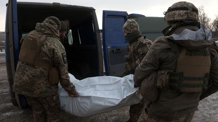 Des soldats ukrainiens transportent le corps d'une victime de la guerre, près de Bakhmut, le 17 janvier 2023. Photo d'illustration. (ANATOLII STEPANOV / AFP)