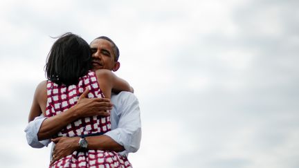 Barack Obama et son épouse Michelle s'enlacent après un meeting de campagne à Dubuque (Iowa), le 15 août 2012. Le président américain a publié sur Twitter une photo de cette scène le soir de sa réélection, le 6 novembre 2012. Son message est à l'époque devenu le plus partagé de l'histoire du réseau social. (JIM WATSON / AFP)