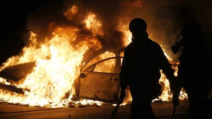 &nbsp; (Une voiture brûlée dans une rue de Ferguson, après la manifestation © REUTERS/Jim Young)