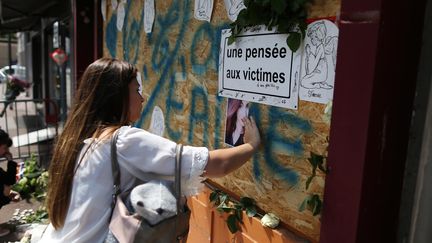 Une jeune femme rend hommage aux&nbsp;victimes&nbsp;de l'incendie&nbsp;du&nbsp;bar Cuba Libre, le 6 août 2017 à Rouen. (CHARLY TRIBALLEAU / AFP)