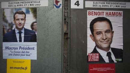 Des photos de Benoît Hamon et Emmanuel Macron sont collées sur des panneaux électoraux parisiens, le 10 avril 2017, à deux semaines du premier tour de l'élection présidentielle.&nbsp; (ROMANE VERCHERE / SIPA)