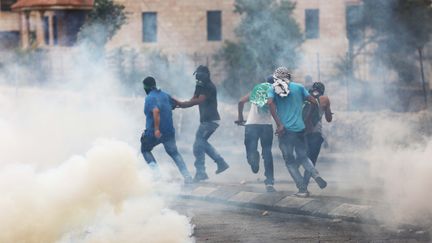 Des Palestiniens vis&eacute;s par des tirs de gaz lacrymog&egrave;nes, le 23 octobre 2015, &agrave;&nbsp;Bethl&eacute;em. (MUHESEN AMREN / NURPHOTO / AFP)