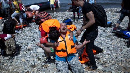 Un réfugié syrien prie à son arrivée sur l'île grecque de Lesbos à bord d'un canoe pneumatique gonflable en provenance de la Turquie.
 (Angelos Tzortzinis / AFP)