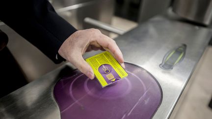 Un usager du pass Navigo&nbsp;à une borne, le 28 novembre 2014, à Paris. (CITIZENSIDE / YANN KORBI / AFP)