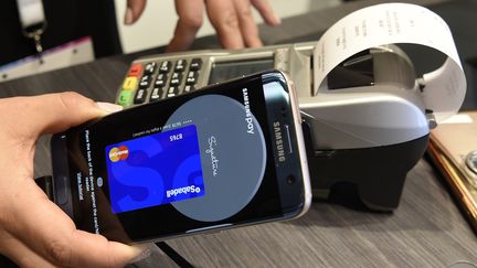 Une personne&nbsp;exposant le système de paiement sans contact Samsung Pay au Mobile World Congress (MWC) de Barcelone, en février 2017. (LLUIS GENE / AFP)