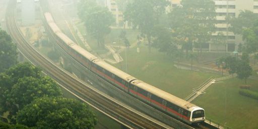 A Singapour, un train surgit du brouillard de pollution arrivé d'Indonésie (21-6-2013). (AFP - Roslan Rahman)